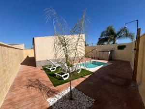 un patio avec deux chaises et une piscine dans l'établissement Villas Privadas EL DESCANSO, à La Rinconada