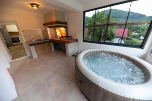 a large bathroom with a tub and a large window at Holiday Residence Šehić in Visoko