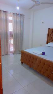 蒙巴萨Arsan Homes 1 bedroom Kisimani Heights的一间卧室，配有一张大床和一扇窗户。