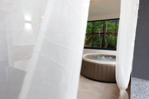 a bathroom with a tub and a window at Holiday Residence Šehić in Visoko +21 photos