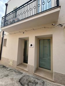 a building with a balcony and two windows at AZ rooms in Noto