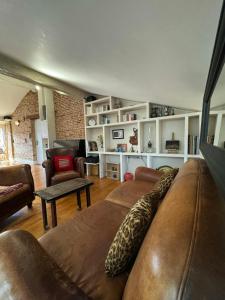 - un salon avec un canapé et des fauteuils en cuir brun dans l'établissement Loft de charme climatisé et sa terrasse, à Toulouse