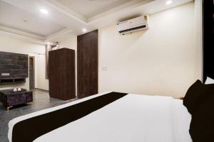 a bedroom with a white bed and a fireplace at Hotel O Paradise in Ghaziabad +22 photos