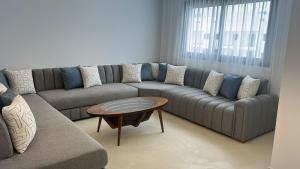 a living room with a couch and a coffee table at Rmilat Garden N8 vue sur la piscine in Cabo Negro