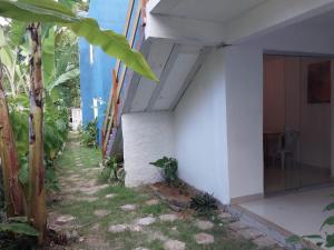 a side view of a white building with a yard at Apartamento Próximo a Pituba in Itacaré
