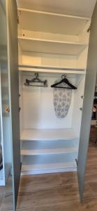 einen begehbaren Kleiderschrank mit weißen Wänden und Regalen in der Unterkunft Entre lac et montagne in Doussard