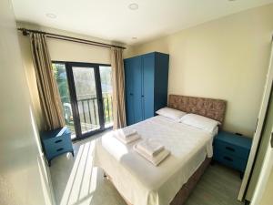 une chambre avec un lit avec des armoires bleues et une fenêtre dans l'établissement Küre Dağları Manzaralı Şömineli ve Bahçeli Villa, à Büyükkıran