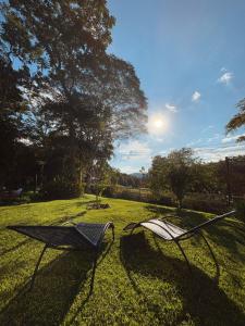 two chairs sitting in the grass in a yard at Cabana Zen - Sítio Gaia Magia in Miguel Pereira +8 photos