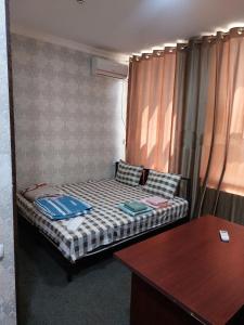 Cama pequeña en habitación con mesa en Hotel, en Muruntau