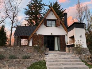 a white house with a black roof at Casa El Ciprés in Potrerillos