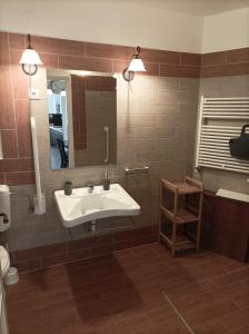 a bathroom with a sink and a mirror at Thermália Vendégházak - Levendula Apartman in Kaba
