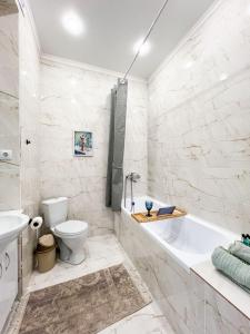 ein Badezimmer mit Badewanne, Toilette und Waschbecken in der Unterkunft Кок-Жайлау 1-комнатная за Хан Шатыром in Astana