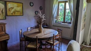 a dining room with a table with a vase on it at Ancienne maison de famille in Roberval +22 photos