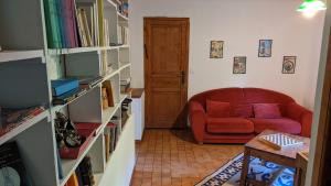 a living room with a red couch and book shelves at Ancienne maison de famille in Roberval