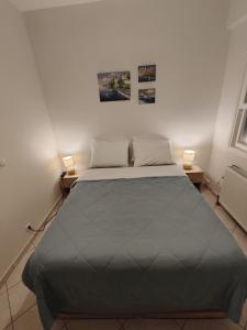 ein Schlafzimmer mit einem großen Bett und zwei Lampen auf zwei Tischen in der Unterkunft Perdika Sunset in Pérdika