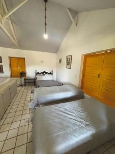 a bedroom with two beds in a room at Loft Cerejeira no Sítio Gaia Miguel Pereira RJ in Miguel Pereira