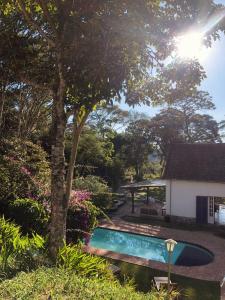 a house with a swimming pool in a yard at Loft Cerejeira no Sítio Gaia Miguel Pereira RJ in Miguel Pereira