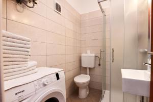 łazienka z toaletą, umywalką i pralką w obiekcie Apartmani Irena Arvaj w Poreču +37 zdjęć