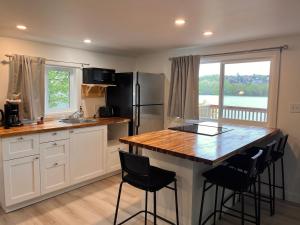 a kitchen with a counter and a kitchen island with chairs at Camping Chalets Lac St-Augustin in Quebec City +10 photos