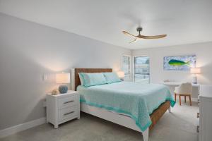 a white bedroom with a bed and a desk at Blind Pass C106 - Upgraded Ground Floor Residence at Blind Pass in Sanibel +21 photos