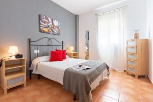 a bedroom with a bed with red pillows on it at YOKOI La Antilla in La Antilla +11 photos