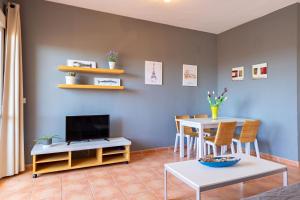 a living room with a table and a television at YOKOI La Antilla in La Antilla