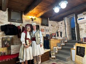 two women in historical clothing standing in a room at Old town Guesthouse Guri in Berat
