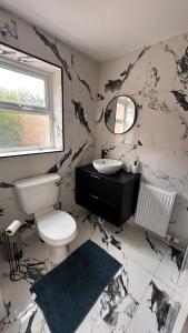 a black and white bathroom with a toilet and a sink at Modern bedroom near town centre in Bridgwater