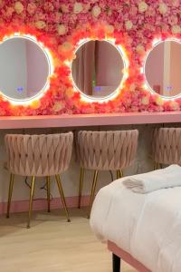 a bedroom with two mirrors and a table with two chairs at Pink Nashville Cottage - Girls' Trip, 12 Min to Broadway in Nashville