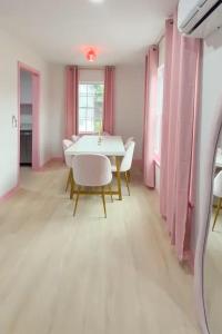 a dining room with pink curtains and a table and chairs at Pink Nashville Cottage - Girls' Trip, 12 Min to Broadway in Nashville