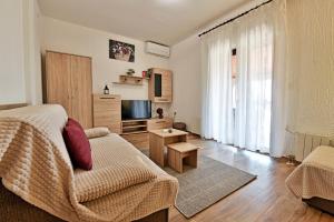 salon z łóżkiem, kanapą i telewizorem w obiekcie Apartmani Irena Arvaj w Poreču