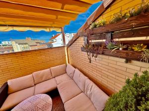 un piccolo balcone con un divano su un muro di mattoni di Ático Guara&Pirineos a Huesca