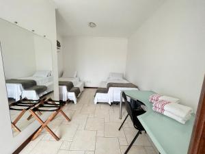a room with two beds and a table in it at Cobertura 403 Braga · Complete apartment with private pool Cabo Frio in Cabo Frio