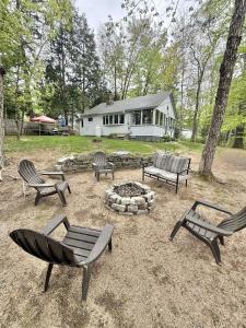 a group of benches sitting around a fire pit at KENDALL COTTAGE LIMIT 6 villa in North Sebago