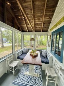 a screened in porch with a table and chairs at KENDALL COTTAGE LIMIT 6 villa in North Sebago +14 photos