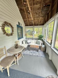 a screened in porch with a table and a couch at KENDALL COTTAGE LIMIT 6 villa in North Sebago