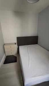 a small bedroom with a white bed and a nightstand at Modern bedroom near town centre in Bridgwater