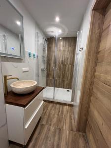a bathroom with a sink and a shower at VipStay - Stilvoll und geräumige Apartments mit Terasse oder Balkon, Küche, kostenloses Parken, WLAN, Smart Tv in Wiesloch +78 photos
