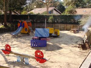 a playground with different types of play equipment in a yard at Maryse in Moliets-et-Maa