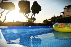 a swimming pool with a yellow boat and palm trees at Sunrise Residence in Santa Domenica