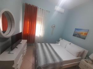 a bedroom with a white bed and a window at George 1 in Gjirokastër +12 photos