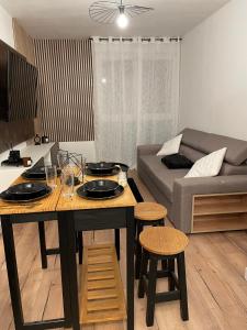a living room with a table and a couch at Évasion chic à Aucamville - Parking Privé - CLIM in Aucamville