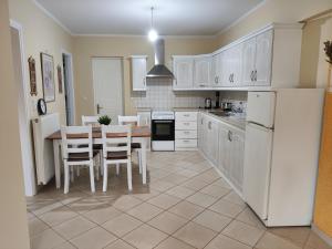 a kitchen with white appliances and a table and chairs at Perdika Beige in Pérdika