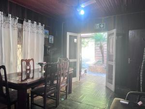 Un comedor con una mesa y sillas y una puerta. en Pousada Vicz, en Águas da Prata