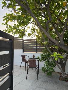a table and chairs on a patio under a tree at Hillview Apartments Chalkis in Chalkida