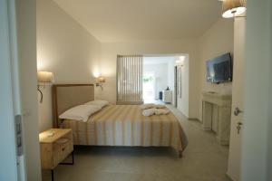 a bedroom with a bed with two towels on it at Praialonga Suites with Pool and Garden in Le Castella