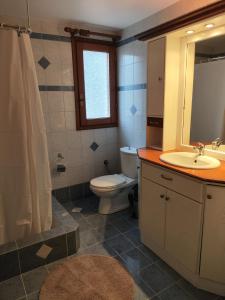 a bathroom with a toilet and a sink and a mirror at Perdika Beige in Pérdika +3 photos