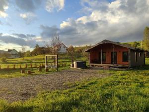 a small house in a field next to a field at Family House Volosianka in Volosyanka
