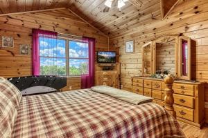 ein Schlafzimmer mit einem Bett und einem TV in einer Hütte in der Unterkunft Brother Bear, Free Attraction Tickets, Hot Tub, WIFI!!! in Sevierville