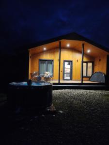 a small house at night with a tub in front of it at Family House Volosianka in Volosyanka